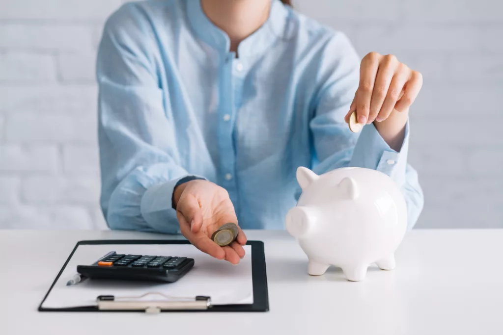 A person putting money in the piggybank.