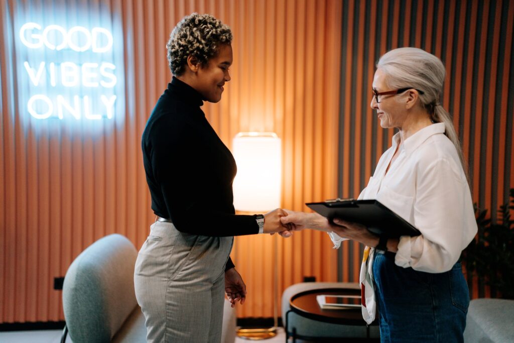 Two women talking and shaking hands